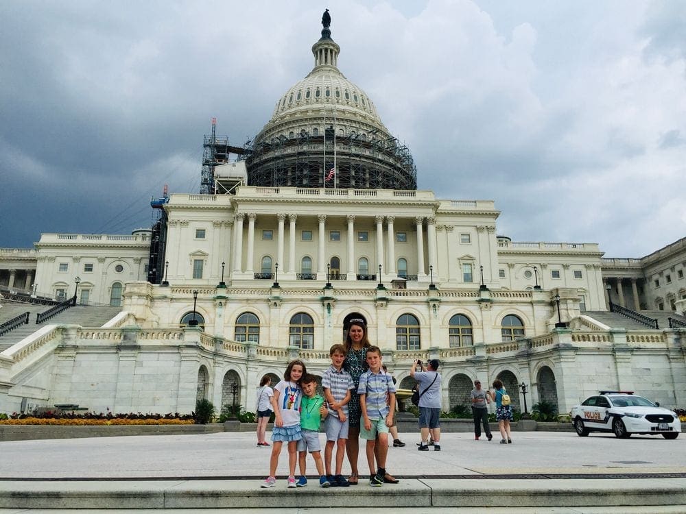 A family of five stands in front of the U.S. Capitol Building in Washington D.C. One of the 9 Things to Do Washington DC with Kids.