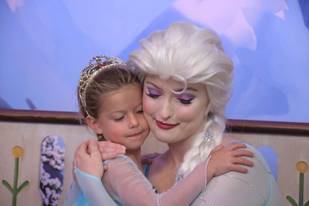 Girl in princess dress hugging Elsa character at Disney World