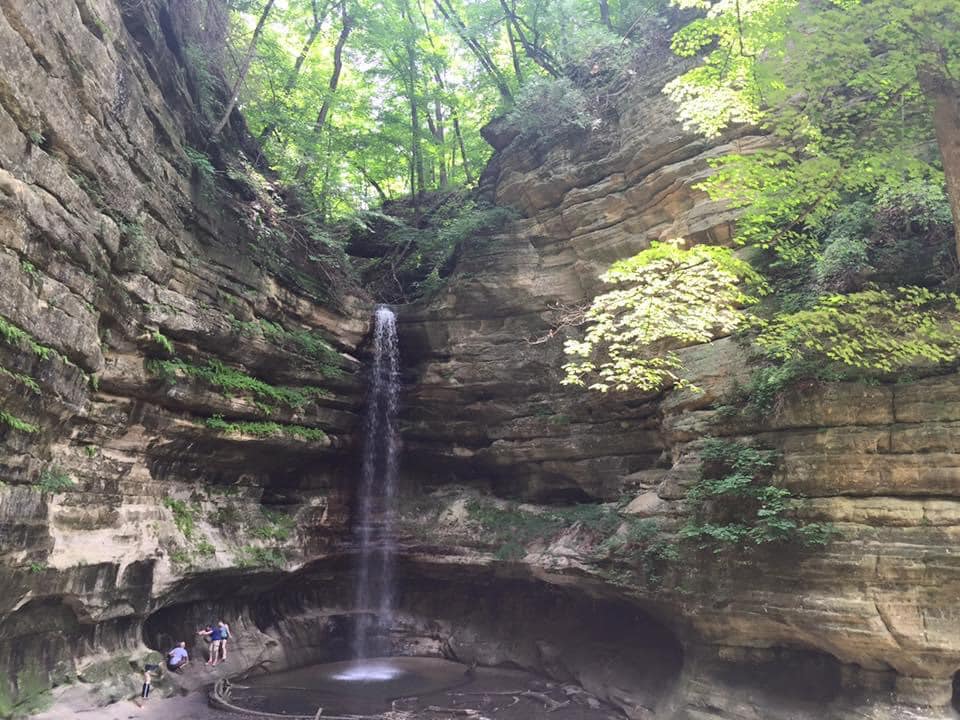 A mom and her young child walk below the sparse waterfall at Starved Rock State Park, one of the best places in Northern Illinois for families