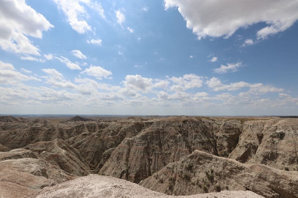 An expansive view of canyons in the Badlands National Park on a sunny day.