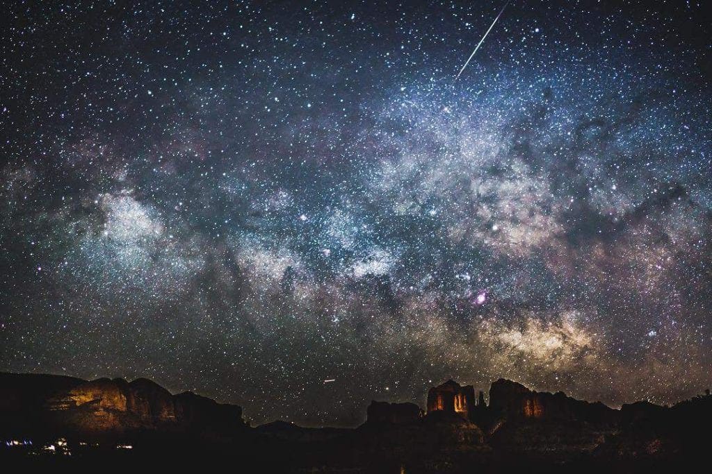 A stunning view of thousands of stars in the Sedona night sky, including a shooting star.
