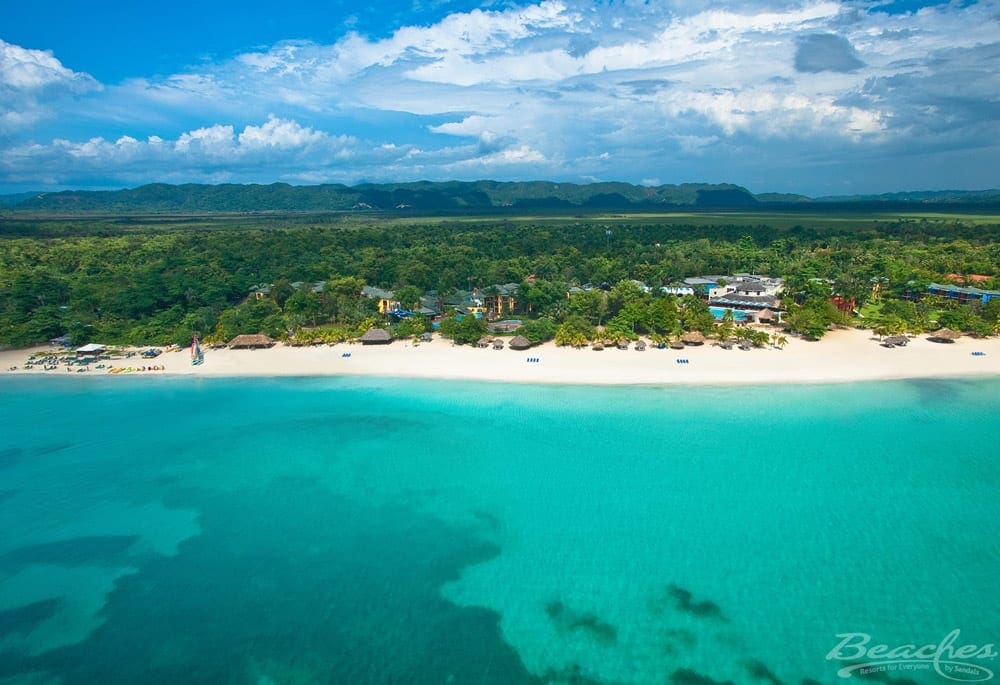 An arial view of the ocean, beach-line, and grounds at Beaches Negril.