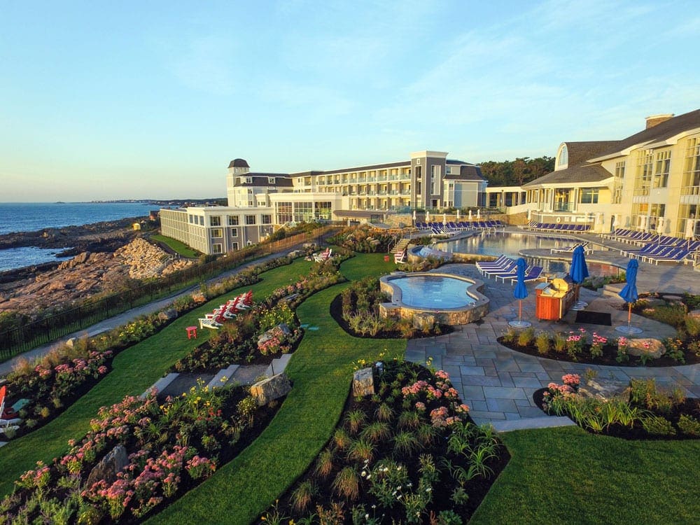 A view of the Cliff House grounds, including lovely flower gardens, the hotel, and an ocean-side view.