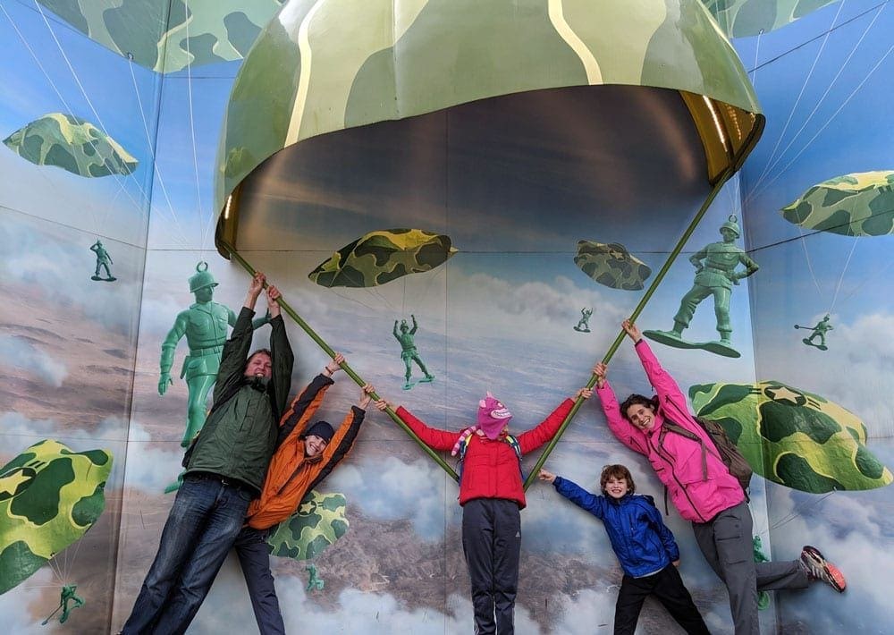Disney Planning Forums can be a huge help to families! Here, a family of five pretends to be falling with an army parachute as part of the Toy Story area of Walt Disney World.