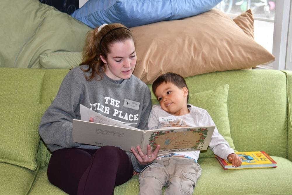 A trained child care provider reads to a young boy at one of the many childcare options in The Tyler Place Family Resort.