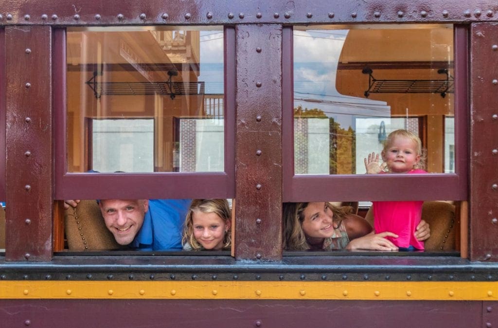 Two parents and their two kids peak out of train windows along the tracks of New Hope, Pennsylvania.