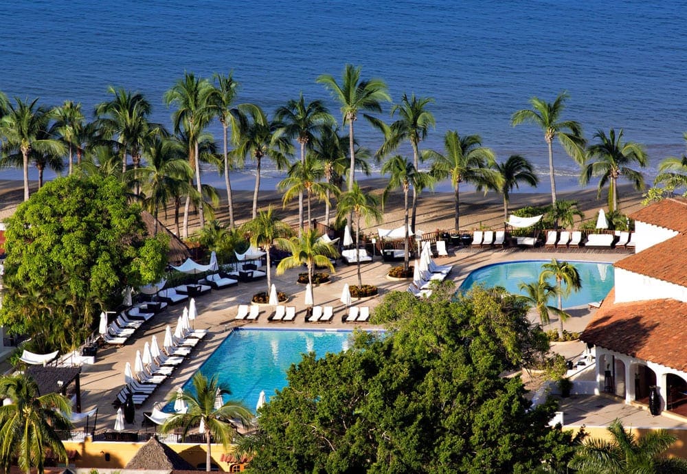 An aerial view of Club Med Ixtapa Pacific, featuring tropical foliage, a large pool, and an expasive beach.