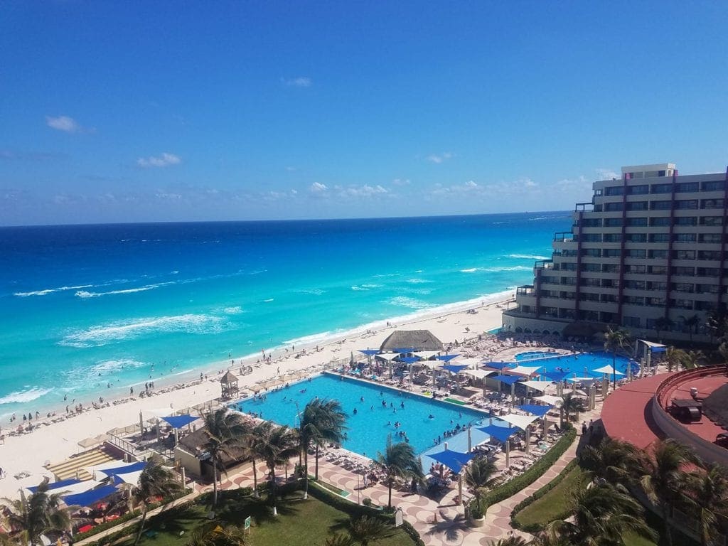 A view of the beach, pool, and grounds of the Crown Paradise Club in Cancun.