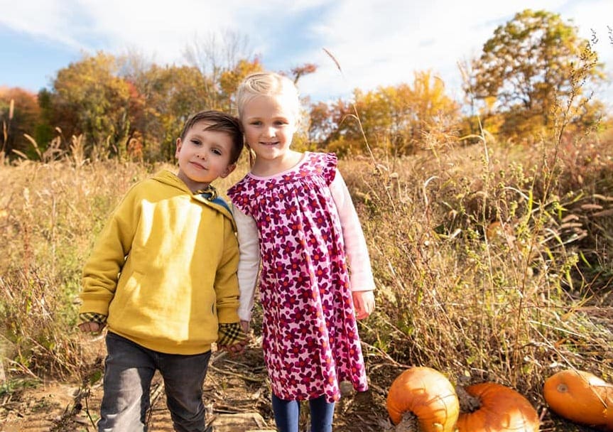 Little girl and a boy in the pumpkin patch