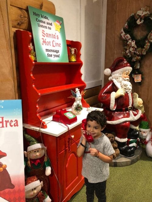 A young boy holds onto a red phone as he calls Santa from Bronner's CHRISTmas Wonderland in Frankenmuth, Michigan.