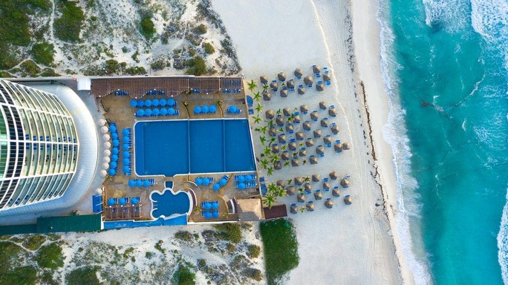 An aeiral view of the Seadust Cancun Family Resort, featuring a large pool, the beach, and the resort.