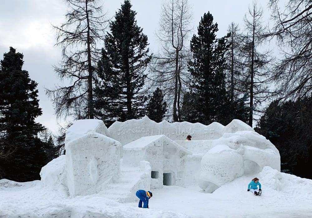 Two kids play on the huge ice castle outside of Suvretta House.