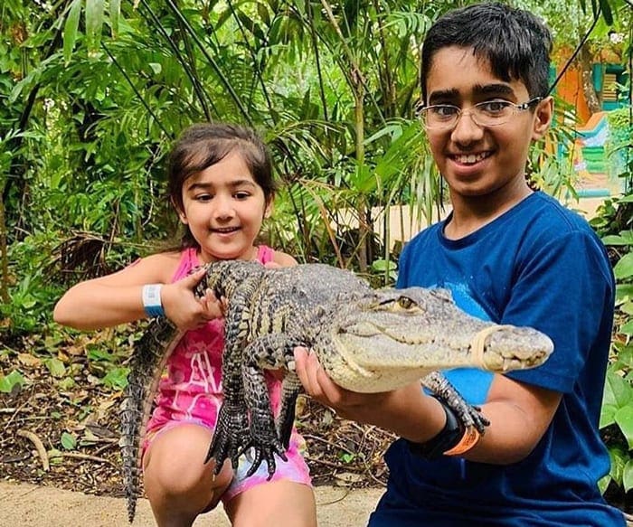 boy and a girl holding crocodile in Croci Can Zoo in Cancun