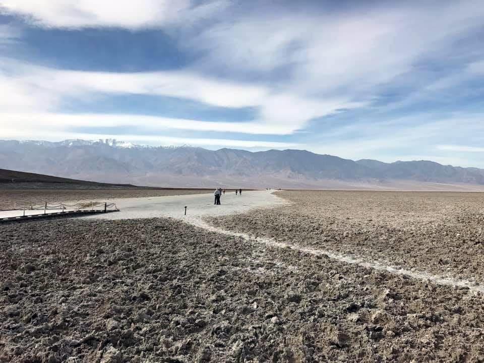 The sparse landscape of Death Valley National Park, with some hikers in the distance.