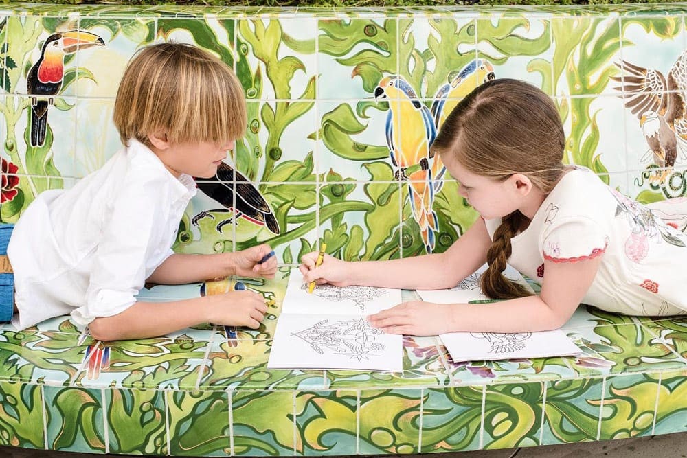 Two kids lie coloring within the kids club at Faena Hotel Miami Beach.