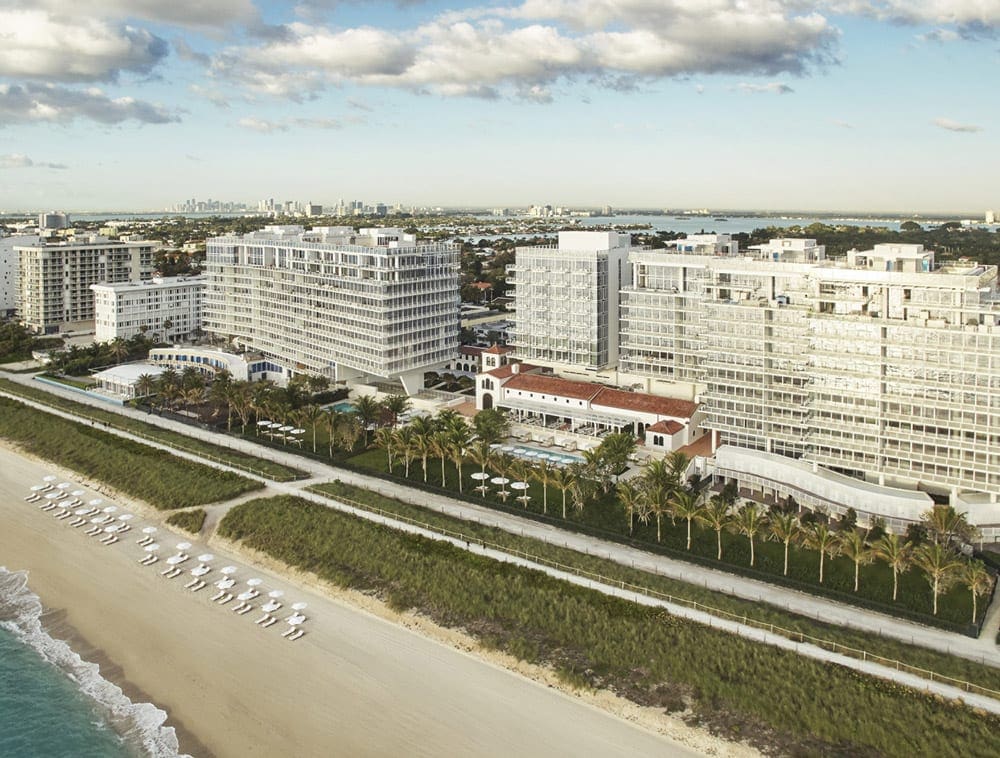 An aerial view of the Four Seasons Surfside in Miami, ones of the best family-friendly hotels in Miami, featuring an expansive white sand beach.