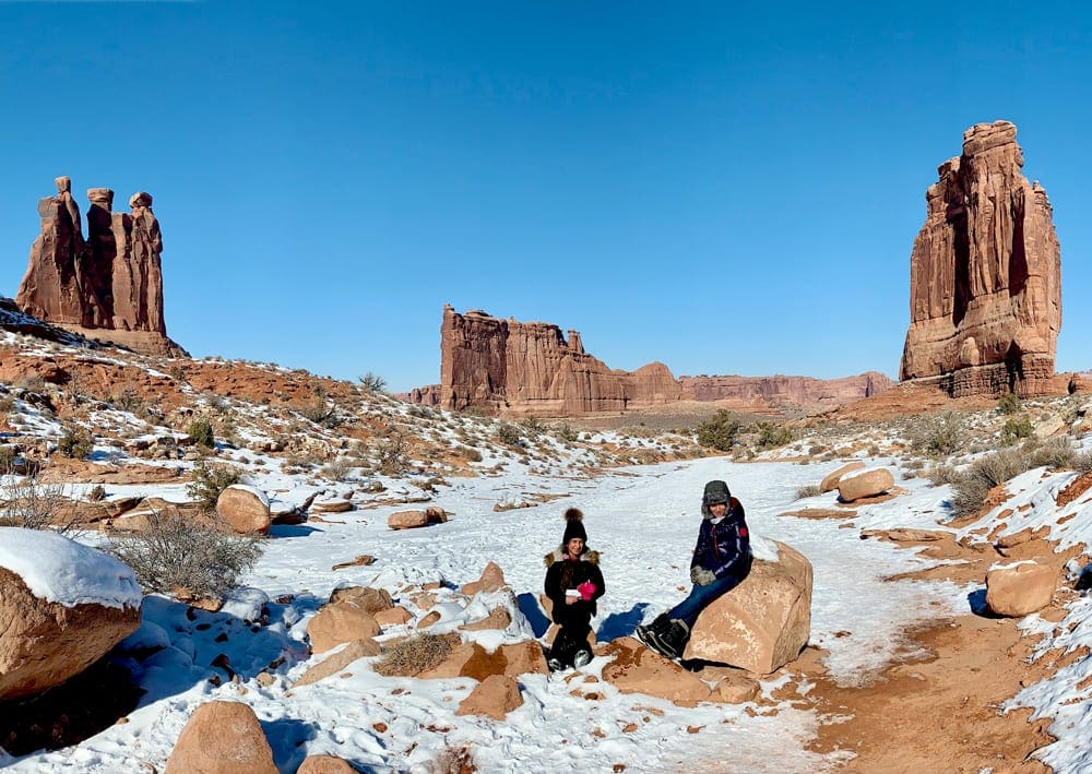 Two Kids sitting while hiking Park Avenue trail in Arches National Park