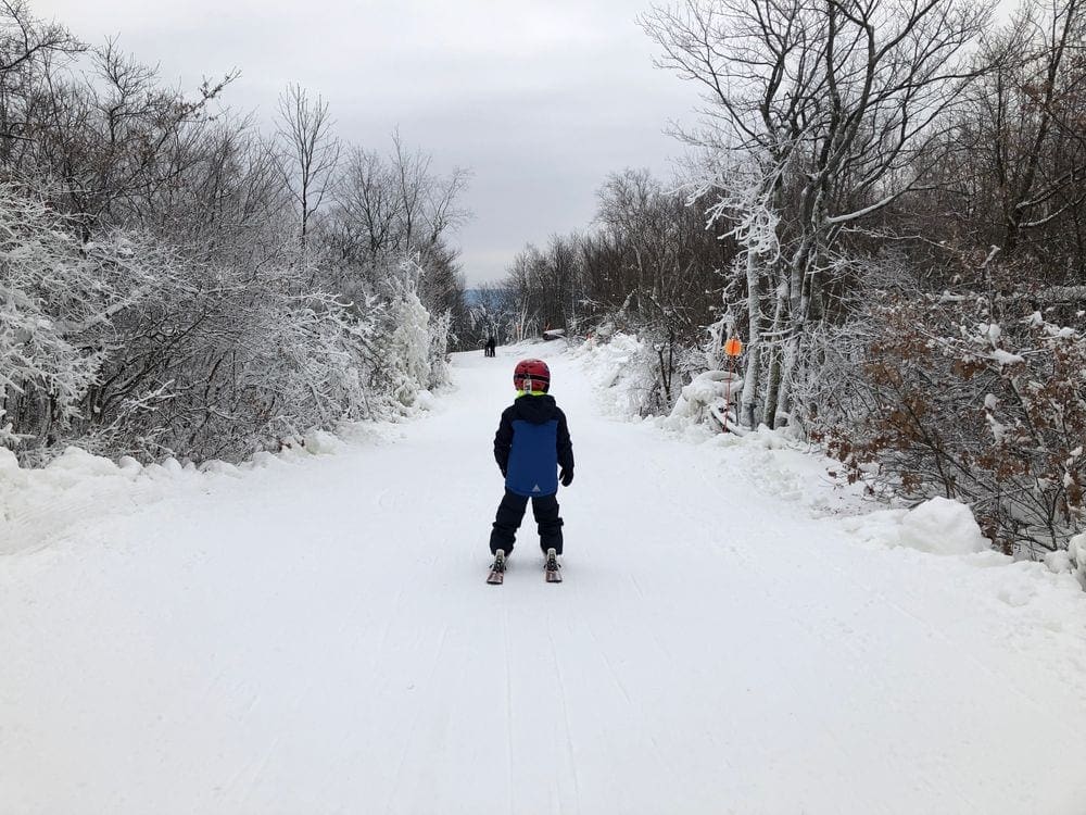 A young child skis down a trail at Catamount Restort, one of the best ski resorts near NYC for families.