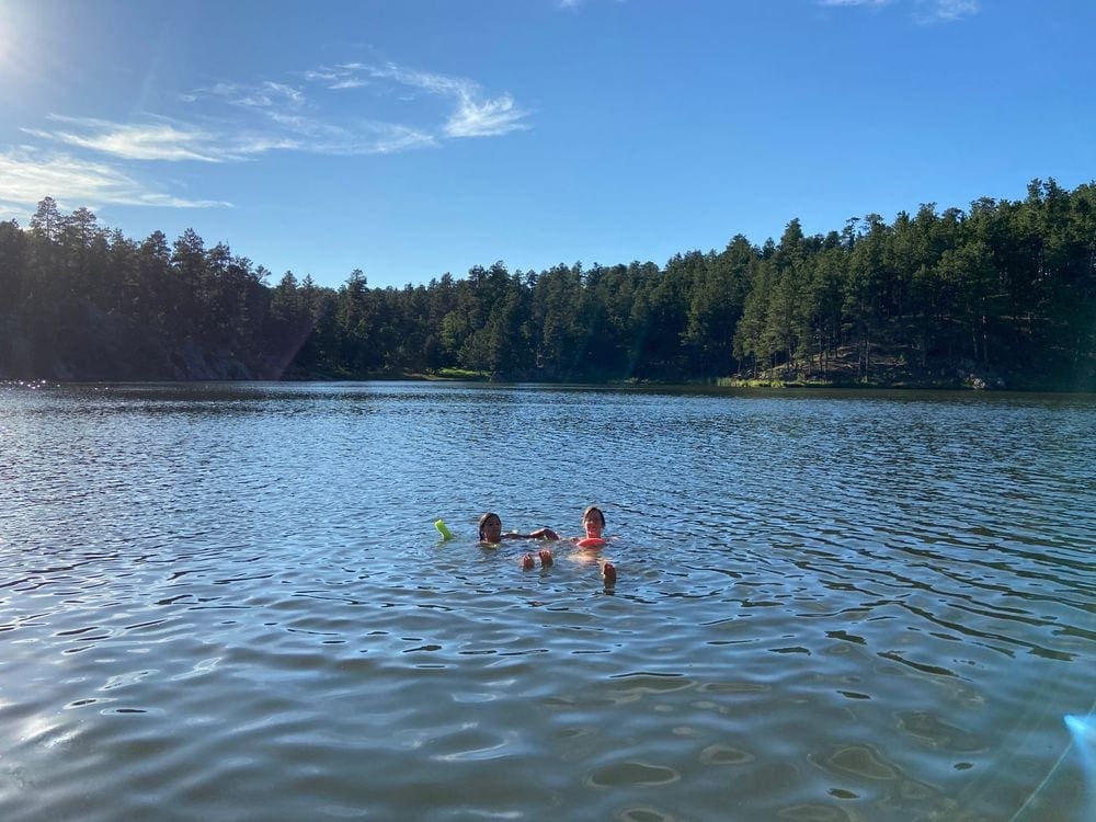 Two adults swim in Horsetheif Lake, one of the stops on this national park itinerary for families.