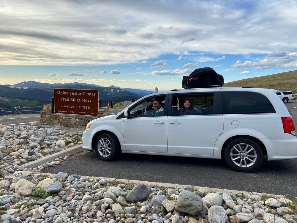 A van is parked in front of a sign for Trail Ridge Store, near the Alpine Visitor Center.