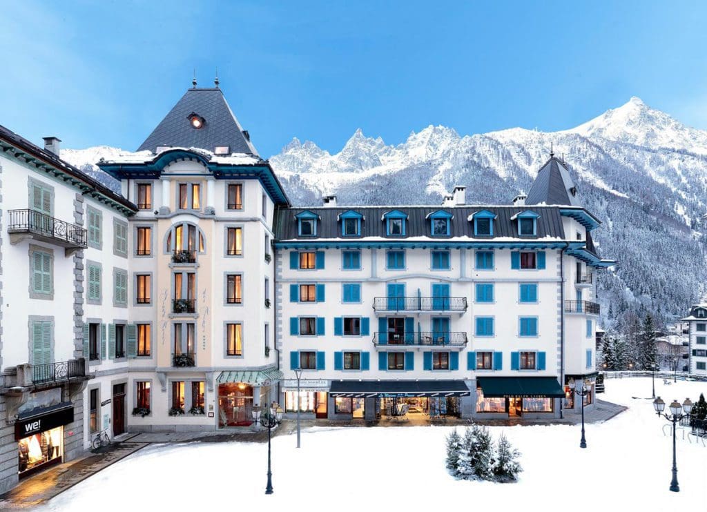 The white buildings of Les Grands Montets Hotel & Spa, with grounds covered in snow.