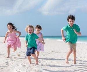 four kids running on the beach in Aruba