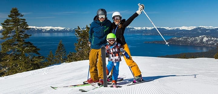 A family of three stands on skis at the top of the Diamond Peak Incline Village, one of the best ski resorts near Lake Tahoe for families.