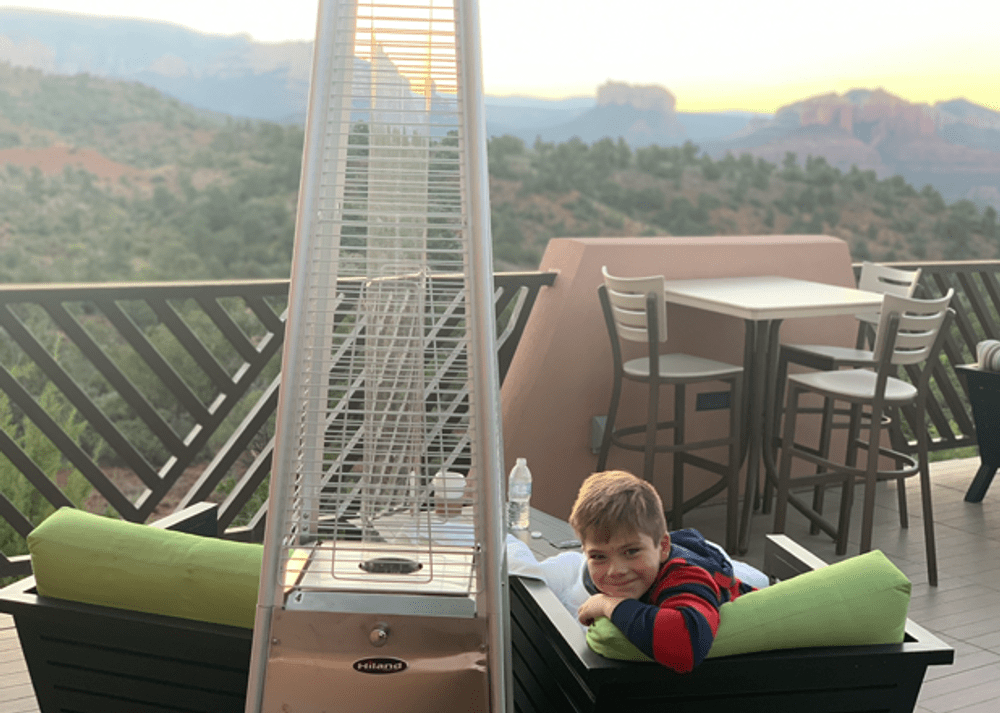 A boy sits by a heater at the Sedona Courtyard by Marriott, one of the best hotels in Sedona for kids.