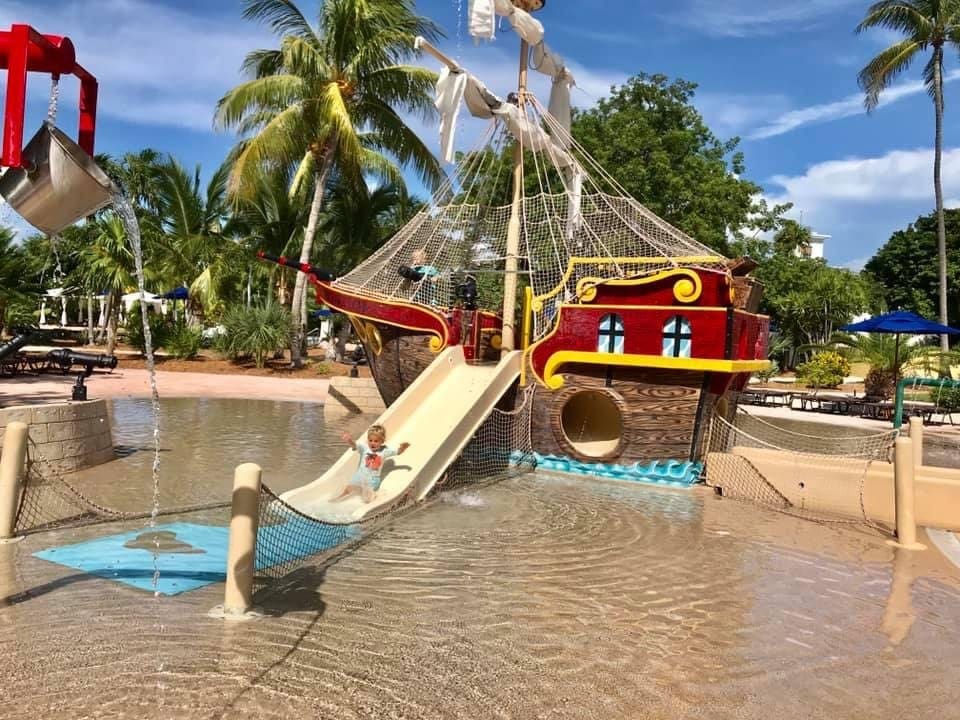 Little kid going down a slide at the Pirate Ship Pool at Hawks Cay, one of the best family hotels in Key West and the Florida Keys