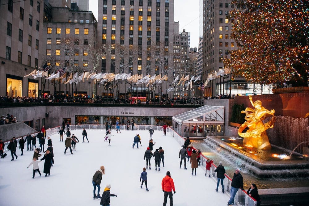 An overhead view of The Rink at Rockefeller Center, featuring a number of skaters during the holidays, one of the best New York City Christmas activities with kids.