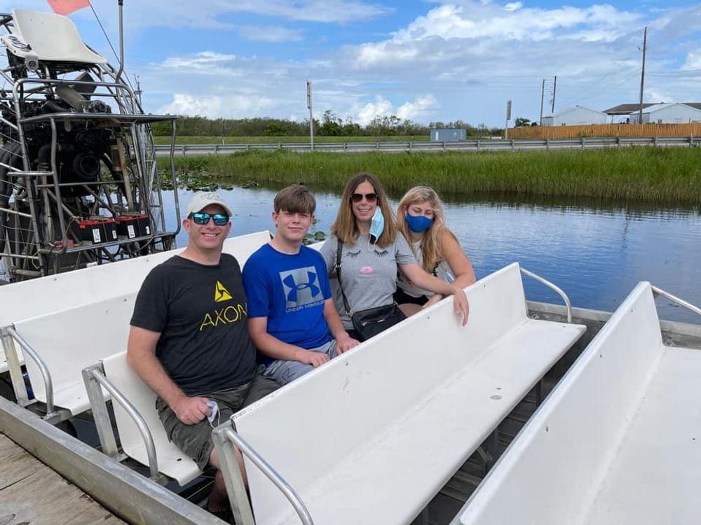 A family of four sits together on an airboat tour in Miami, one of the best US cities for a Memorial Day Weekend with kids.