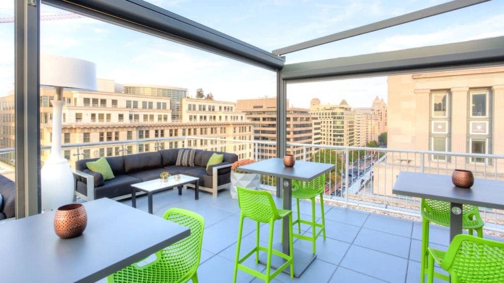 The enclosed patio at Hyatt Place Washington DC/White House, featuring lime green seating.