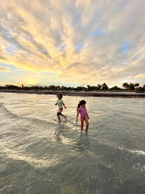 Two kids play in the water at sunset in Key Biscayne.