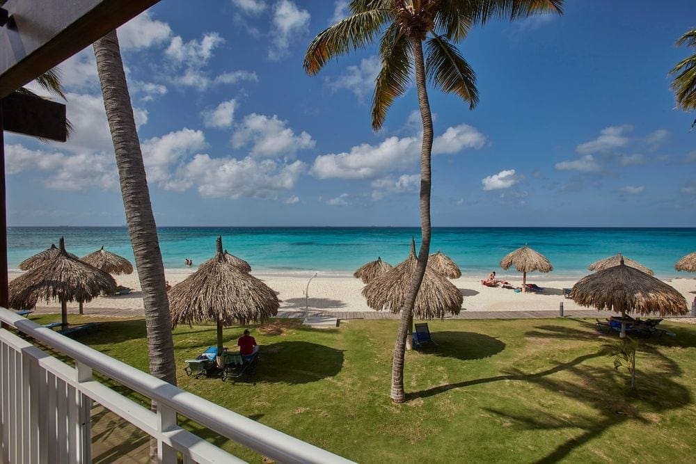 The grounds of Tamarijn Aruba All Inclusives, featuring cabanas and a beach.