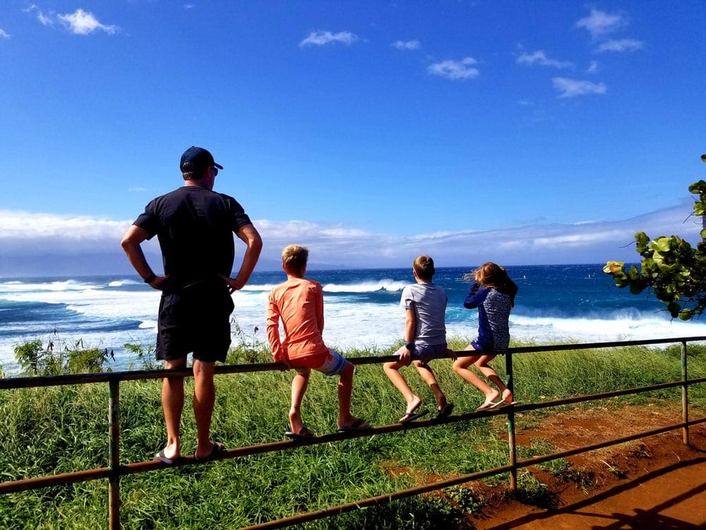 Three kids and their dad peer off into the distance at Ho’okipa Lookout.