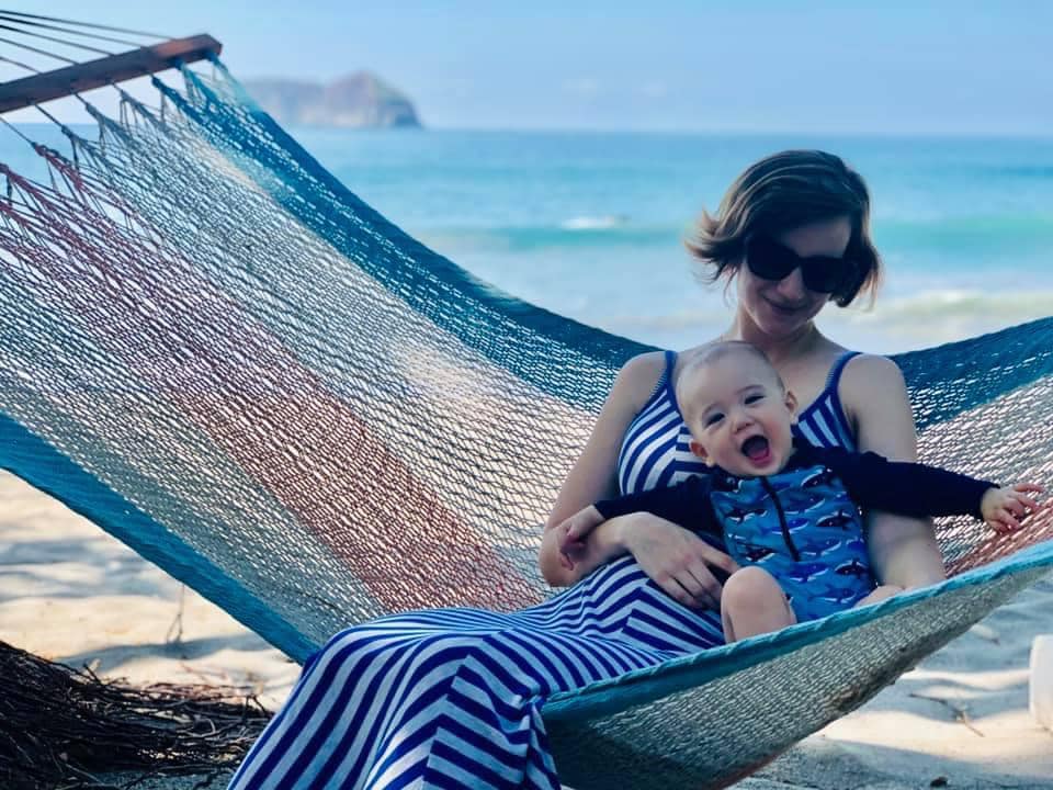 A mom rests on a hammock with her infant son in Costa Rica.