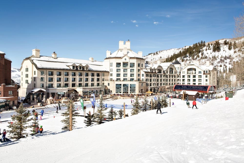 A few skiers meander the grounds on a sunny, winter day at Park Hyatt Beaver Creek Resort and Spa, one of the best ski-in/ski-out resorts in the U.S. for families.