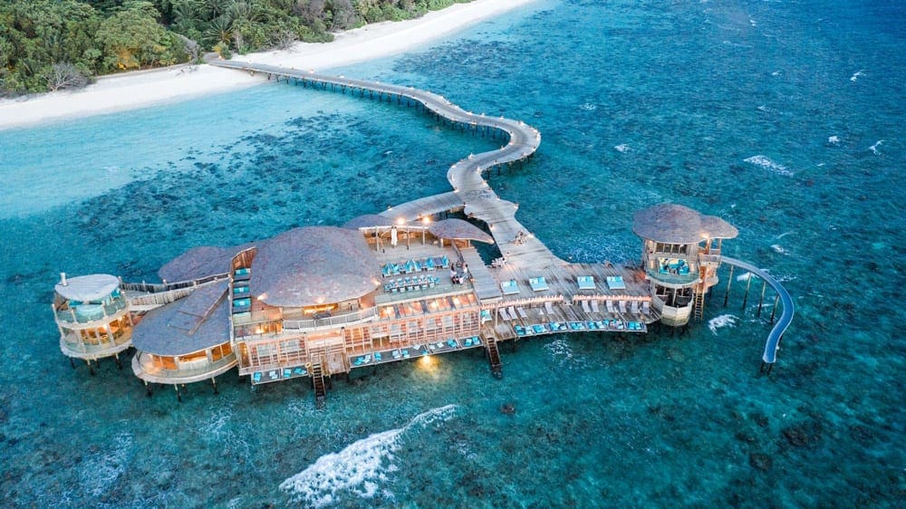 The over ocean resort buildings of Soneva Fushi, ones of the best Maldives hotels with slides for kids, featuring a slide in the Maldives.