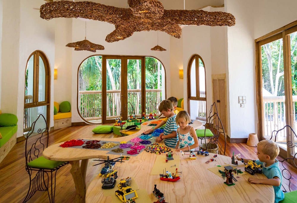 Inside the Den Lego Room, two kids play in Soneva Jani, one of the best Maldives hotels with slides for kids..