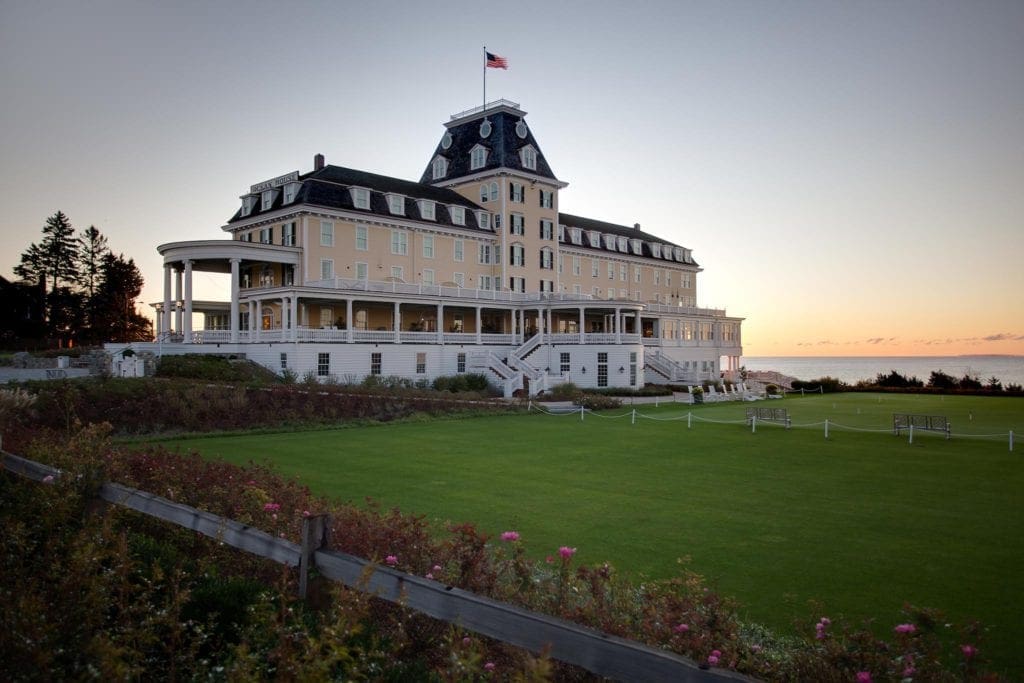 The main building for Ocean House standing proudly during sunset along the oceanfront.