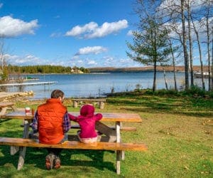 A dad and his daughter sit at a picnic table enjoying lunch in Door County.