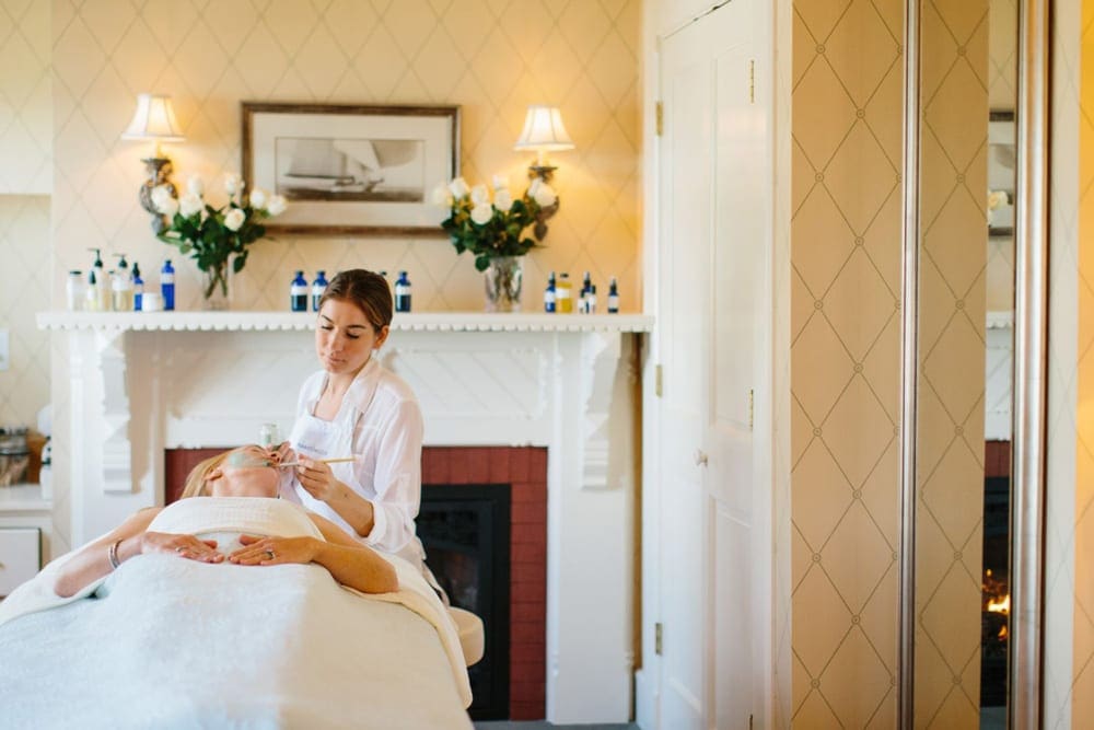 Inside the spa at the Castle Hill Inn, where a staff member is doing a facial on a guest.