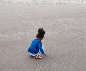 An African American toddler plays in the sand at Ogunquit Beach in Maine.