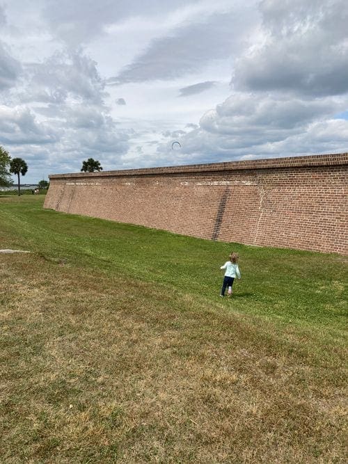 A toddler runs along a wall of Fort Moutrie near Charleston.