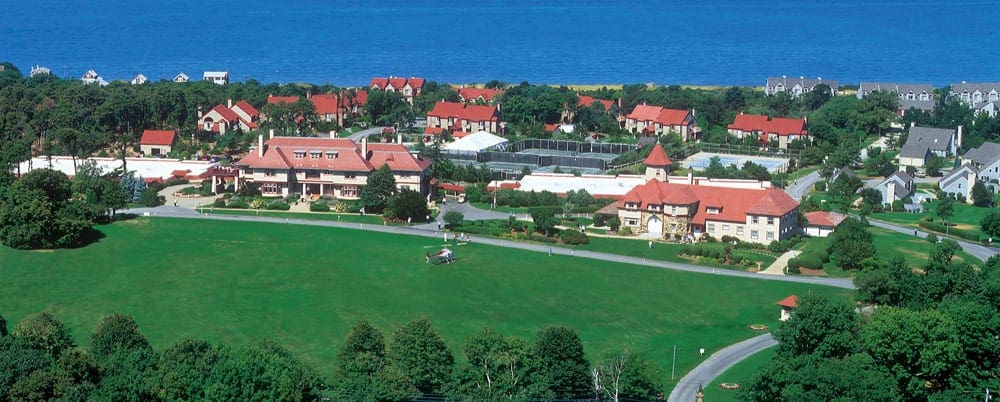 An aerail view of Ocean Edge Resort and Golf Club, featuing several buildings and cottages on a sunny day.
