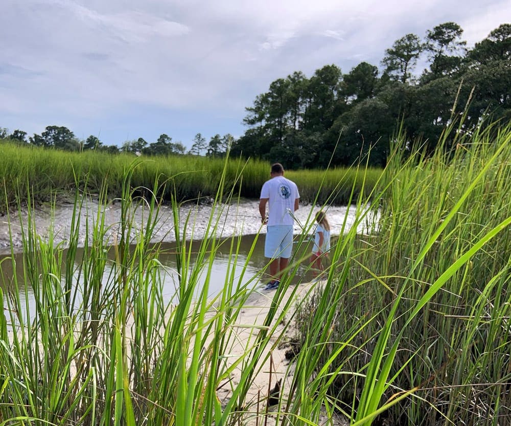 Little girl and dad fishing among the reeds near Charleston.