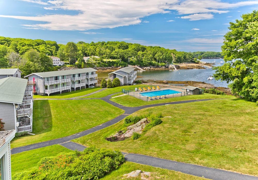 An aerial view of Smuggler’s Cove Inn, one of the best beach resorts in the Northeast for families, featuring green lawns and ocean front views.