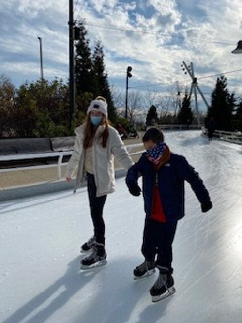 A mom and her older son skate along a rink at Maggie Delay Park in Chicago.