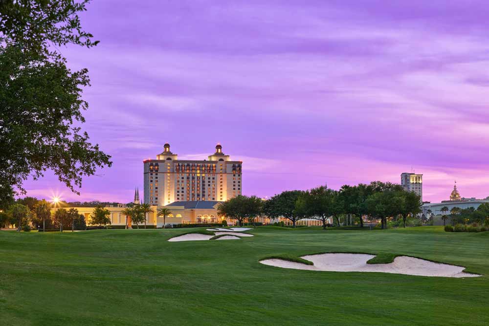 The The Westin Savannah Harbor Golf Resort & Spa across the golf greens during a purple sunset.