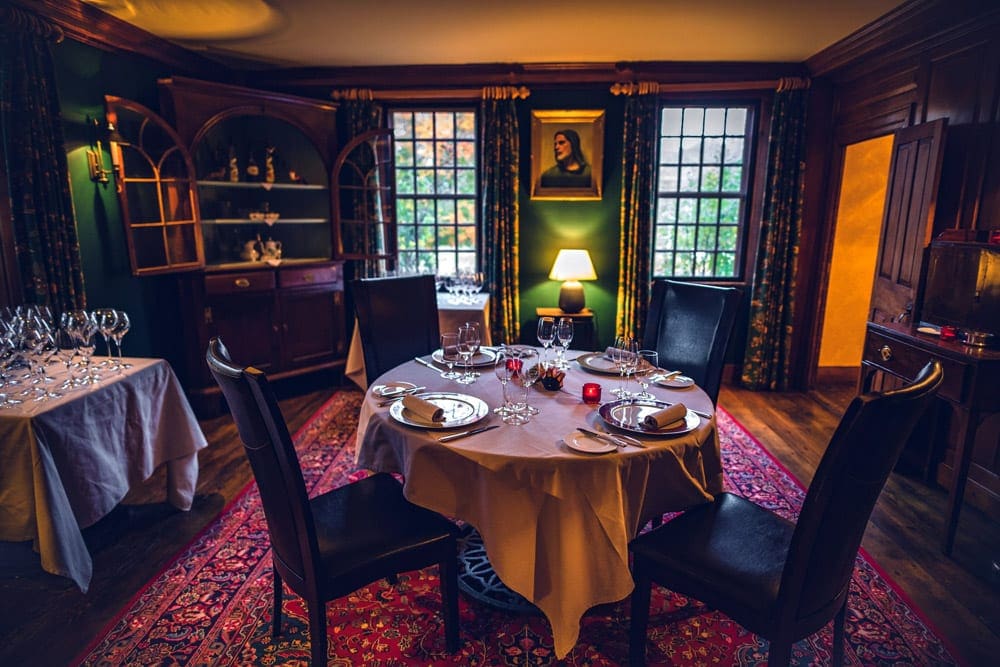 A charming dining area at Winvian Farmone, one of the best locations for a romantic getaway in the Northeast, featuing chic linens and mood lighting.